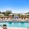 pool with reclining seats and lush landscaping