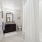 bathroom with a large mirror and walk-in shower